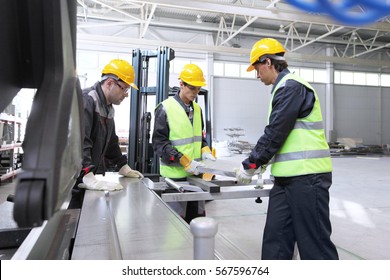 Workers In Uniform In CNC Machine Shop With Lathes