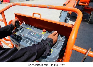 Workers are use control panel to driving the Orange articulate boom lift or telescopic boom lifts and bucket crane mounted on truck to safety for working at heights and articulating boom lift.