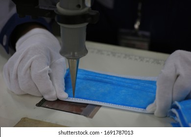 Workers Use Welders To Attach Metal Nose Holders To Surgical Masks. A Close-up