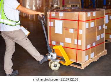 Workers Using Hand Pallet Jack Unloading Packaging Boxes in Storage Warehouse. Delivery Shipment Boxes. Supply Chain. Warehouse Shipping Transport and Logistics.