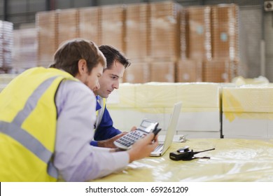 Workers using laptop in warehouse - Powered by Shutterstock