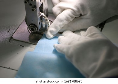 Workers Are Using Machines To Sew The Edges Of Surgical Masks.