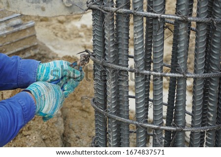Workers are using steel wire to bind steel bars for foundation structures in the chemical plant construction area.