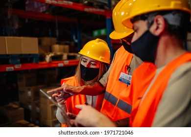 Workers Using Technology And Wear Face Mask To Prevent COVID-19 Coronavirus Infection In Distribution Center. Business Teamwork Concept.