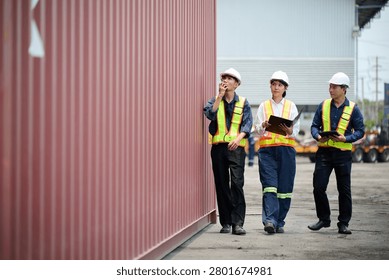 Workers walking and inspecting cargo containers
