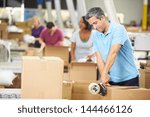 Workers In Warehouse Preparing Goods For Dispatch