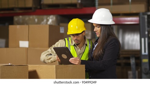 Workers In Warehouse Use Digital Tablet