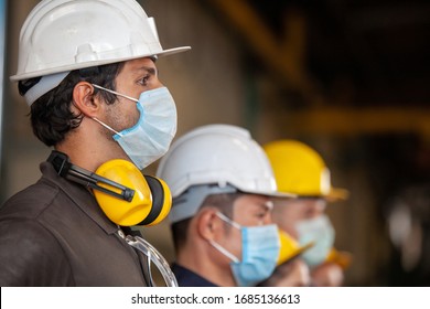 Workers wear protective face masks for safety in machine industrial factory 