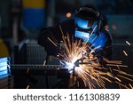 Workers wearing industrial uniforms and Welded Iron Mask at Steel welding plants, industrial safety first concept.