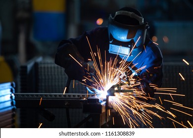 Workers wearing industrial uniforms and Welded Iron Mask at Steel welding plants, industrial safety first concept. - Powered by Shutterstock