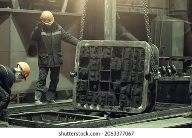 Workers in work with mold after metal casting in steel mill foundry - Powered by Shutterstock