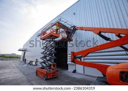 Workers working on the construction site of the new factory industry for boom lift roof