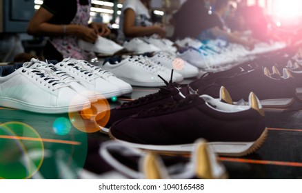 workers working on lacing process in footwear factory conveyor