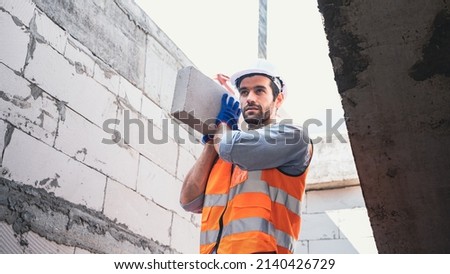 Workers,engineers,handsome faces from the Middle East,Iran, Turkey are working on lifting lightweight bricks,AAC in house and building construction projects.Combination of PPE, gloves, hard hat,vest.