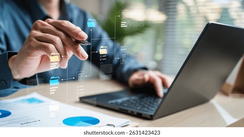 Workflow process solution plan management. Flowchart implement strategy interface diagram. A person is using a laptop to create a diagram on a piece of paper.