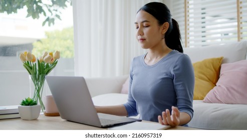 Workforce break time deep breath close eyes comfy workspace sit smile easy on floor relax enjoy yoga at cozy sofa couch help boost power energy in work at home office for asia people young teen girl.