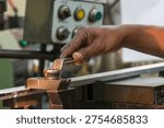 The  work-holding setup process, a critical step before machining begins. It shows a machine operator using a spanner, wrench to adjust the torque, securing the workpiece to the clamp or support base on the CNC milling machine. This ensures stability and safety during high-speed processing.