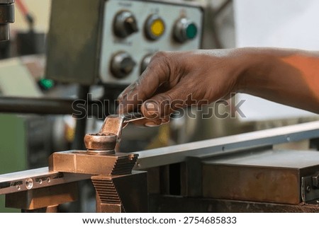 The  work-holding setup process, a critical step before machining begins. It shows a machine operator using a spanner, wrench to adjust the torque, securing the workpiece to the clamp or support base on the CNC milling machine. This ensures stability and safety during high-speed processing.