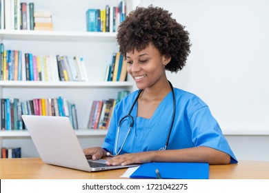 Working afro american nurse or medical student at computer at hospital
