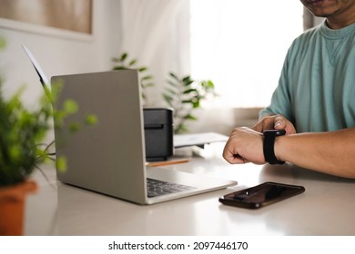 Working All Day, Close-up Of Man Wearing Smart Watch Using Laptop And Drinking Coffee While Doing Housework.