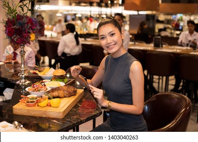 Working Asian Woman Black Hair Having Lunch Big Piece Steak Grill Dinner Of Western Food In Fusion Restaurant Cafe And Eat Alone. Concept Enjoy Eating Myself For Good Food Life