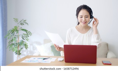 Working Asian Woman In The Living Room. Telemeeting. Video Conference. Remote Work.