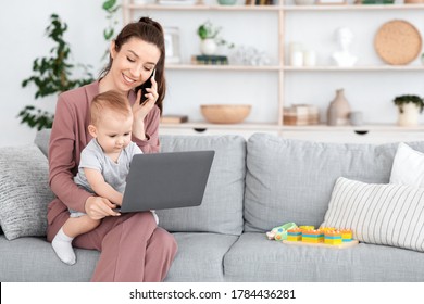 Working With Baby. Young Mom Talking On Cellphone While Toddler Typing On Laptop In Her Laps, Free Space