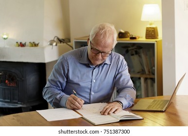 Working Businessman Sitting At A Desk With A Computer In A Cozy Home Interior Making Calculations