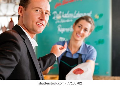 Working in a butcher's shop - shop assistant and client - Powered by Shutterstock