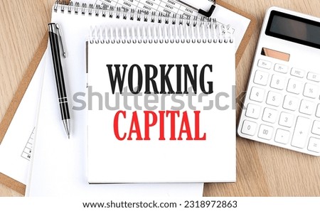 WORKING CAPITAL is written in white notepad near calculator, clipboard and pen. Business concept