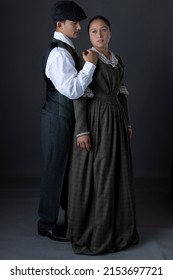 A working class Victorian couple standing against a studio backdrop
