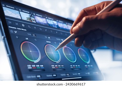 Working with a color wheel. filmmaker or colorist, working with footage on his tablet by pen tool, in a creative office studio. - Powered by Shutterstock