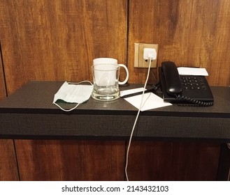 Working comfort zone table against wooden wall with traditional dialing phone tea cup, pen, mobile charger and wood table - Shutterstock ID 2143432103