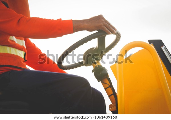 Working concept\
Of labor : Side view, male worker working, father driving yellow :\
Soft focus and blurry\
background