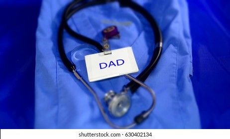 Working Dad In Healthcare. Blue Scrubs With Stethoscope And Name Badge. 