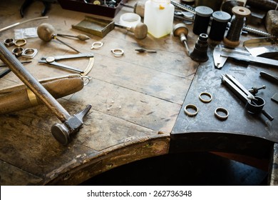 Working desk for craft jewelery making with professional tools. Grunge wooden table. View from above. Copy space.