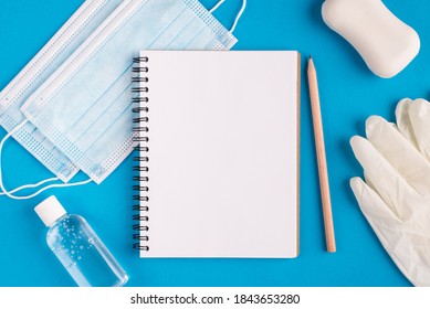 Working Education Study From Home Concept. Top Layout Flatlay Close Up Photo Of Empty Blank Clear Paper Page Open Sketch Pad Disinfection Bottle Rubber Gloves Face Surgical Medical Mask On Table Desk