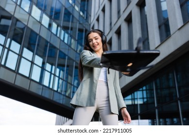 Working Enviroment Young Girl Wearing Headphones And Dressed In Buisness Suit On Background Of Buisness Centre Heading To Restaurant For Buisness Meeting With Colleaugues.