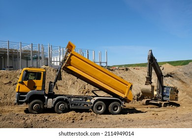 Working excavator and dumper truck at construction site