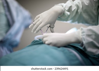 Working Hands Of Surgeon With Forceps