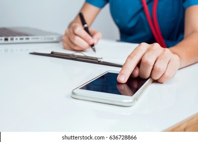 Working Hard Of Medical Doctor Female Using Mobile To Record Patient Insurance Historical To Paperwork At Clipboard.