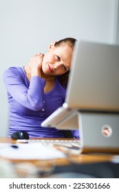 Working Too Hard - Young Woman Working On A Computer At An Office, Having Sore Back, Being Overloaded With Work, Sitting Too Much, Putting Too Much Stress On Her Eyes,..