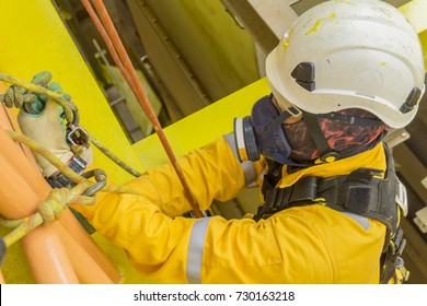 Working At Height. A Commercial Abseiler With Respiratory Protection And Fall Arrestor Device Doing Inspection On Oil And Gas Platform.