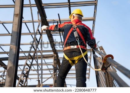Working at height equipment. Fall arrestor device for worker with hooks for safety body harness on selective focus. Worker as a background. Foto stock © 