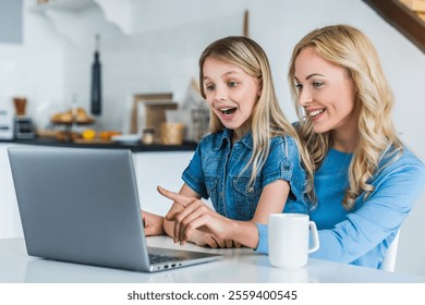 Working from home office with kid. Happy mother and daughter shopping online, using laptop together. Woman hugging child. Freelancer workplace at kitchen table. Female business, virtual communication. - Powered by Shutterstock