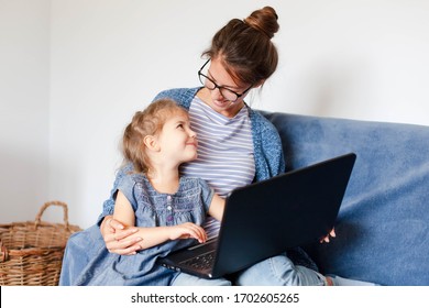 Working From Home Office With Kid. Mother And Daughter Using Laptop And Internet. Freelancer Workplace. Happy Woman Teaching Little Child. Distance Learning, Isolation, Homeschooling. Lifestyle Moment