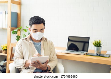 Working from home web designing graphical user interface UX UI, using computer laptop and tablet device designing creative planning innovative idea, protective facemask quarantine coronavirus covid-19 - Powered by Shutterstock