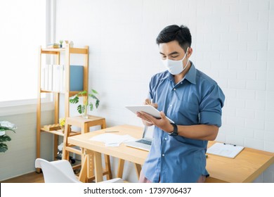 Working from home web designing graphical user interface UX UI, in office drawing using tablet device designing creative planning innovative idea, protective facemask quarantine coronavirus covid-19 - Powered by Shutterstock