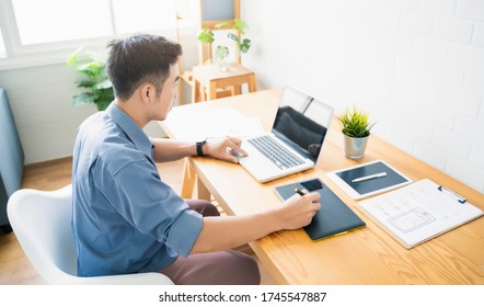 Working from home web designing graphical user interface UX UI, home office using computer laptop and pen sketching graphics tablet device creative planning innovative ideas, asian man quarantine  - Powered by Shutterstock