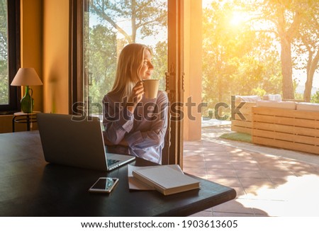 Working from home. Woman talking on video call with Family, using smartphone and drinking tea. Online chat. Spend free time on terrace. Staying connected, Social distancing, internet, chatting. Work.